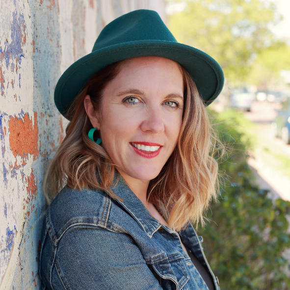 Ingrid Reiger leaning up against a wall wearing a green hat