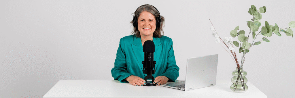 Laura McRae Podcast Consultant siting at a desk recording a podcast episode
