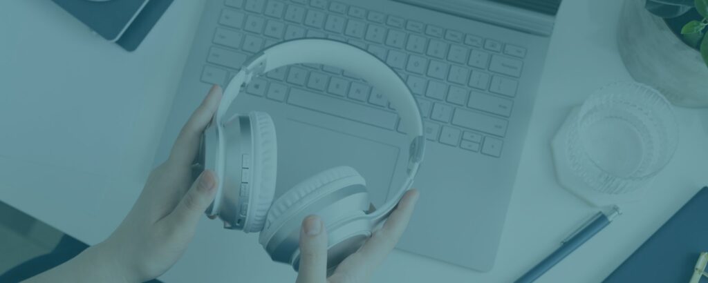 White headphones and a laptop ready to start a podcast